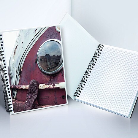 Spiral-bound note pad made from white paper with printed hard cover
