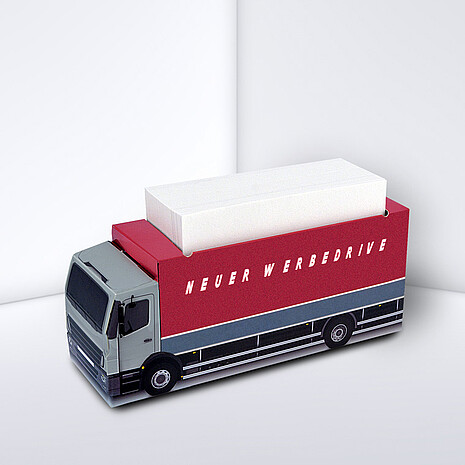 Lorry-shaped, printed cardboard box with white notes